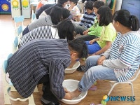 학생들의 발을 씻겨주는 우암초교 교사들