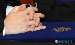 두손 꼭 모은 신임 판사