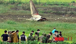 추락한 훈련기 뒤로 수습되는 조종사 시신