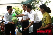 찜통 더위 속 풍물시장서 장보는 세 사람