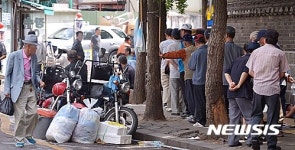 무료 급식소 앞 길게 줄지어 선 노인
