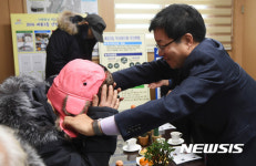 어르신께 방학복 입혀 드리는 염태영 수원시장