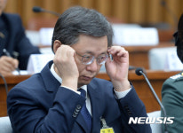 안경 고쳐쓰는 우병우, 매서운 눈빛