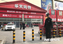 베이징 롯데마트 앞에 서있는 경찰관