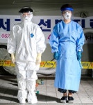 무더위에도 두꺼운 방호복 벗지 못하는 코로나 최전선 선별진료소