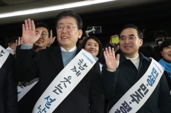 '웃는 설날' 어깨띠 두른 이재명, 용산역서 전장연 마주치자…