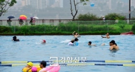[경향포토]우산쓴 시민들과 수영즐기는 시민들
