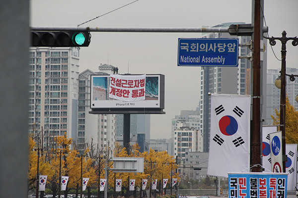 민주노총 건설 노동자들, 국회 인근 광고탑에서 고공농성 현장 일당 2만 원 삭감안 철회를 요구