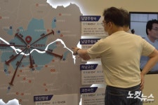 3기 신도시 안내게시판 확인하는 방문객들