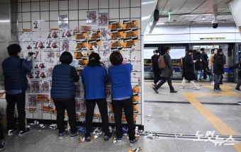 전장연 전단 떼는 서울교통공사 관계자들