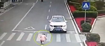횡단보도 앞에 멈춰선 차를 향해  ‘꾸벅’ 인사하는 아이