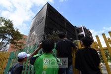 [서울포토] 검게 그을린 은명초등학교를 바라보고 있는 학생들
