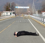 호송차량 막겠다…날 밟고 가라 청송 교도소 앞 한 주민, 누워서 1인 시위