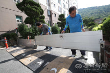 [포토뉴스] 장마 대비 차수벽 점검하는 아파트 관리인