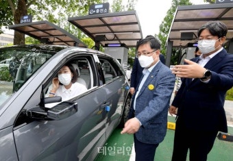 국회 전기차 공공급속충전기 준공식에서 대화하는 이춘석 국회 사무총장과 김성환-장혜영 의원