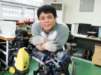 엎드려 휠체어 수리하는 사나이