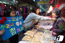 전통시장 상인들에게 카네이션 걸어드리는 어린이들