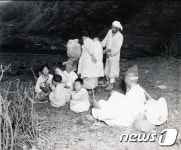 헌병대 사이에서 이동을 준비하는 피난민 가족