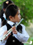 맑은 눈으로 선배들 따라하는 어린이 플룻 연주자