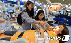치과 진료용 체어 체험하는 관람객들