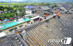지진피해 가옥 지붕에 올라간 문화재 기능인들