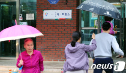우산 쓰고 투표소로