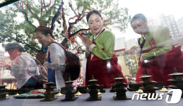 합장하며 사리 살펴보는 불교 신자들