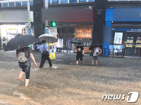 물에 잠긴 횡단보도 건너는 시민들