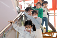 손수건으로 코와 입을 막고 대피하는 어린이들 