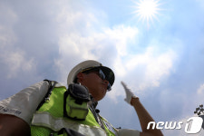 폭염에 교통신호 제어기 고장, 수신호하는 경찰관