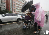 휠체어에 우산쓰고...폭풍 뚫고 상봉장으로
