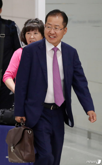 밝은 표정으로 귀국하는 홍준표 전 대표