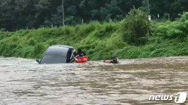 청송 길안천 급류에 떠내려 오던 차에서 구조되는 여성운전자