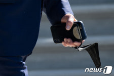 백악관 나서며 휴대폰 꽉 잡고 있는 바이든 대통령