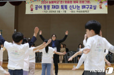 배구 수업에 앞서 아이들과 준비운동하는 장미란 차관