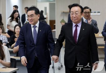 김관용 민주평통 수석부의장과 손잡은 태영호 사무처장