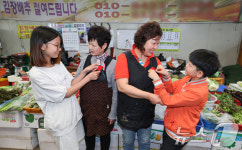 전통시장 상인에게 카네이션 달아주는 어린이