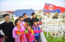 北 배천군 역구도농장에 들어선 주택을 바라보는 주민들