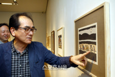 [SS포토]오윤 화백 작품 설명하는 매제 김익구