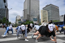 흰색 가면 쓴 시민 50여명이 광화문 횡단보도를 네 발로 건너간 이유