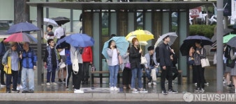 [사진] 알록달록 우산으로 꽉찬 빗속의 정류장