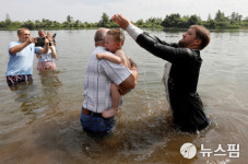 [사진] 러시아 출림 강에서 세례받는 아기