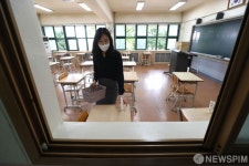 책상 위에 손소독제 놓는 선생님