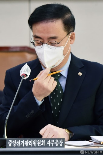 마스크 고쳐쓰는 김세환 중앙선거관리위원회 사무총장