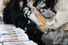 두 손 가득 교과서 받은 신입생들