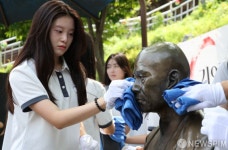 마음으로 만해동상 청소하는 여학생