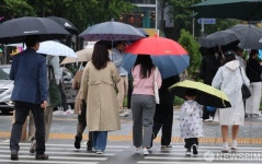 우산속 세종대로 사거리 통과하는 시민들