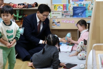 어린이집 아이들에게 인형 선물하는 김문수 장관