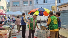 "더위엔 미소 한 병"…청도로타리클럽, 동곡시장서 생수·부채 나눔 봉사