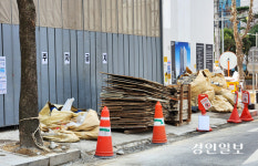 건축 자재 쌓인 인도, 차도로 내몰린 사람